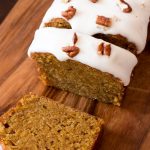 sliced iced carrot loaf cake with pecans.