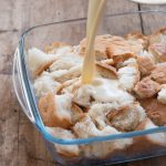 Creamy custard being poured over pulled bread pieces to create the most amazing easy bread pudding.