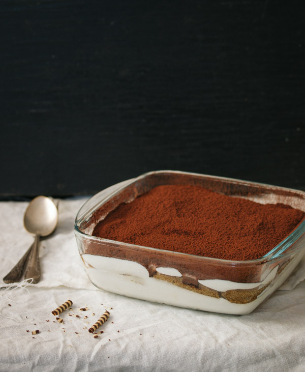 Completed layered tiramisu dusted with cocoa powder.