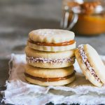 Classic alfajores filled with dulce de leche and rolled in shredded coconut | prettysimplesweet.com