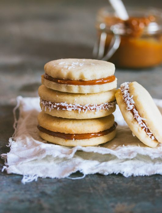 Classic alfajores filled with dulce de leche and rolled in shredded coconut | prettysimplesweet.com