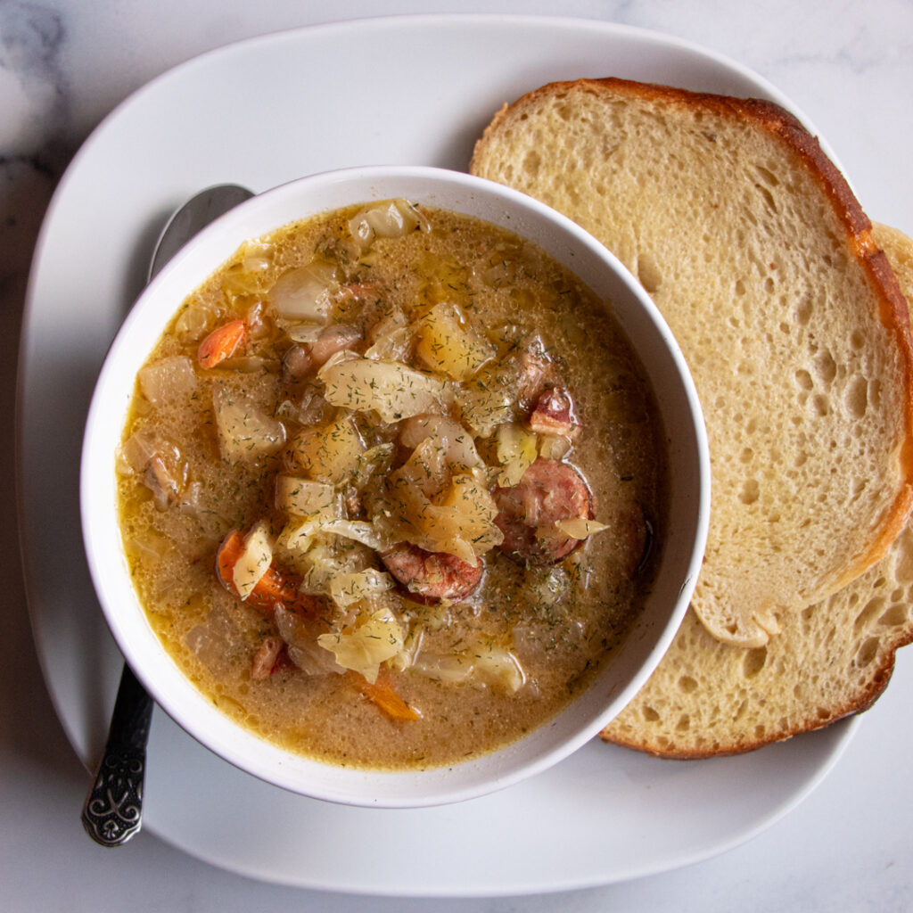 bowl of sauerkraut soup with side of bread