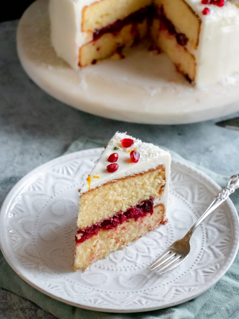 slice of orange layer cake with cranberry filling and cream cheese frosting
