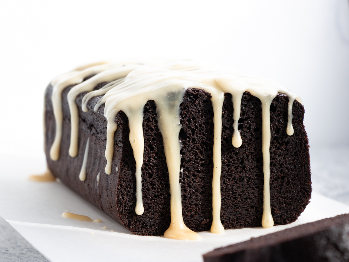Extra dark chocolate pound cake with vanilla sauce drizzling down the sides.
