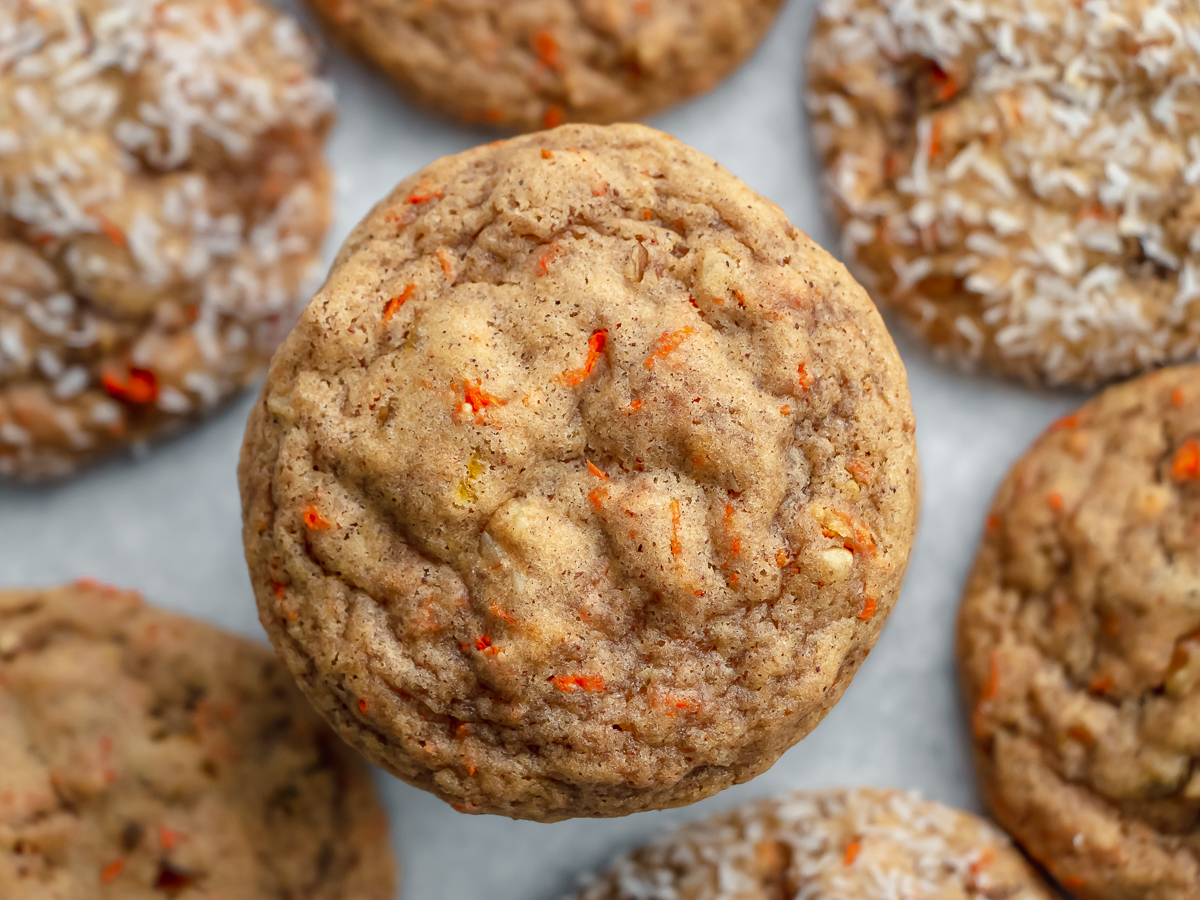 closeup view of easy carrot cake cookie tops with bits of orange carrot visible in the baked cookie.