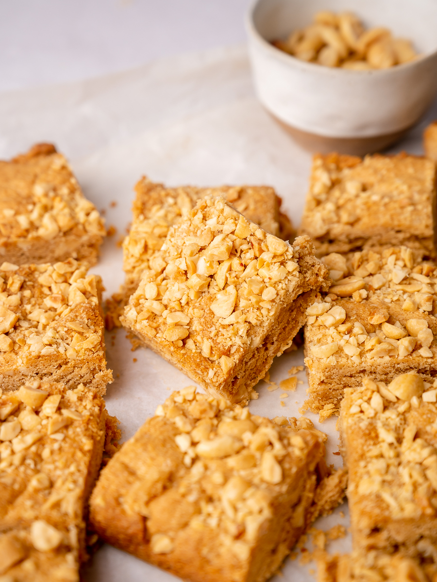 Peanut butter blondie bars with peanuts on top.