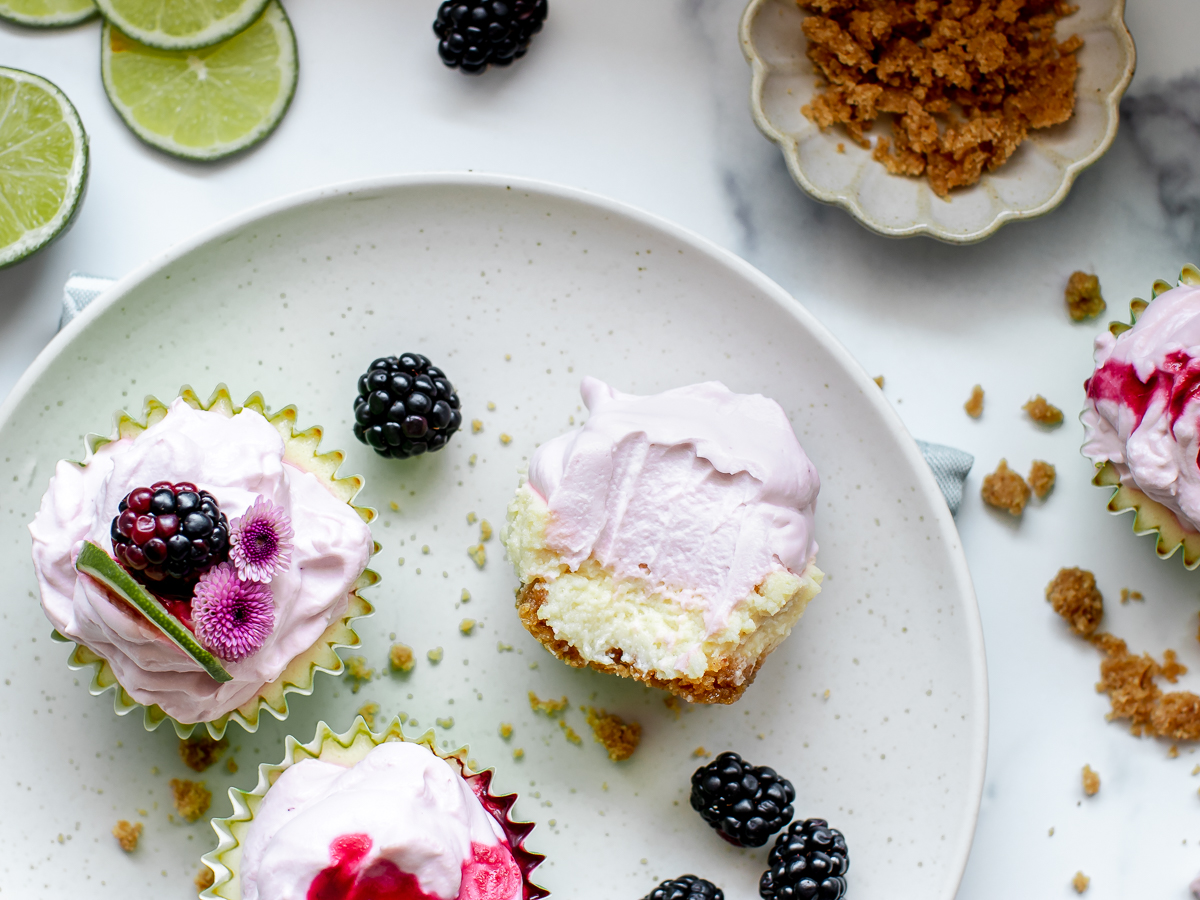 Mini blackberry key lime pies with a view of the middle cut open.