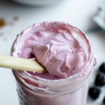 A jar of light purple whipped blackberry frosting made with mascarpone cheese and fresh blackberries.