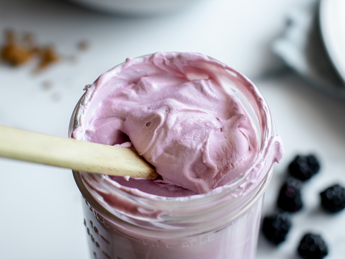 A jar of light purple whipped blackberry frosting made with mascarpone cheese and fresh blackberries.