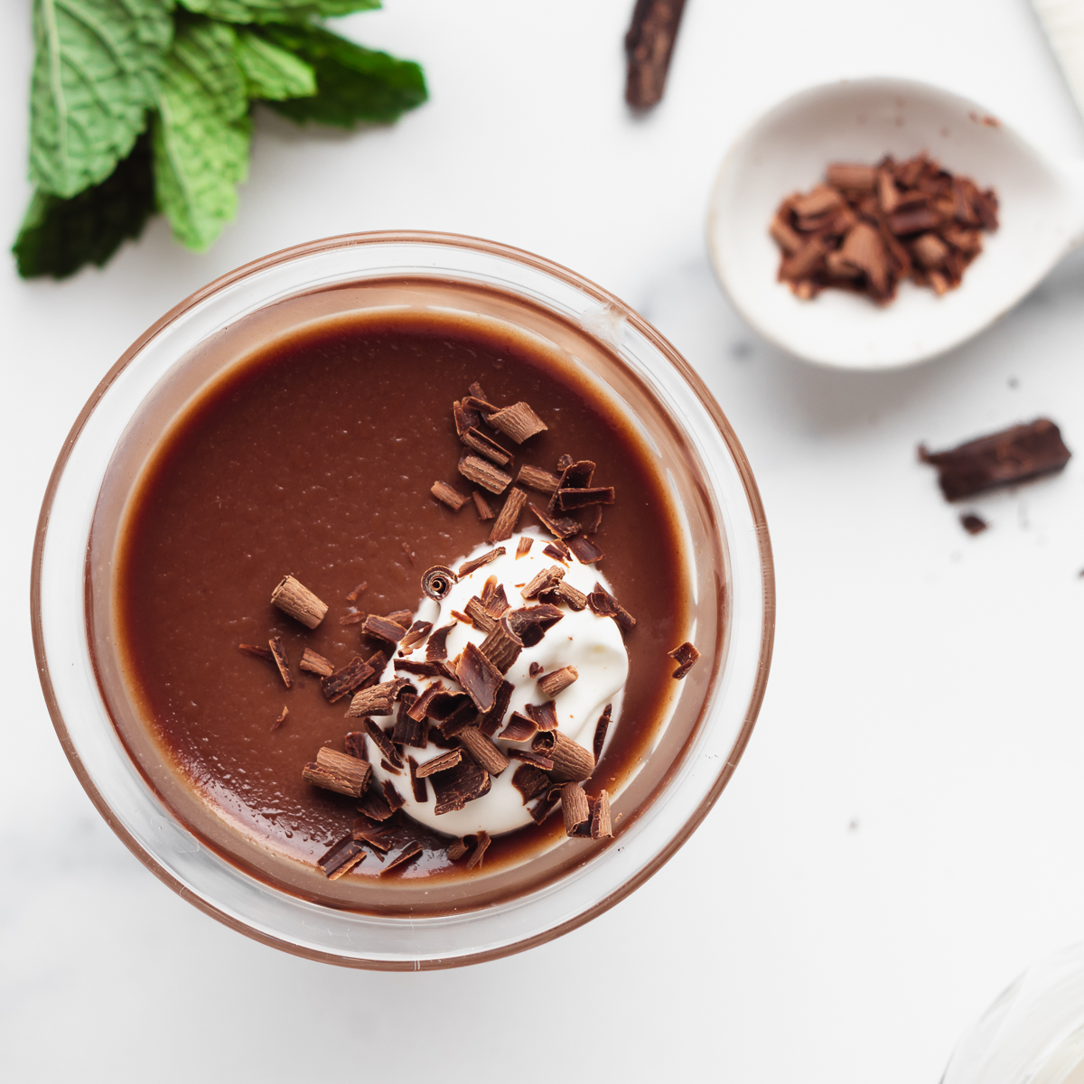 Chocolate Panna Cotta with shaved chocolate and a dollop of whipped cream.