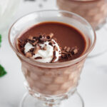 Chocolate Panna Cotta in a vintage glass dish, topped with whipped cream and shaved chocolate.