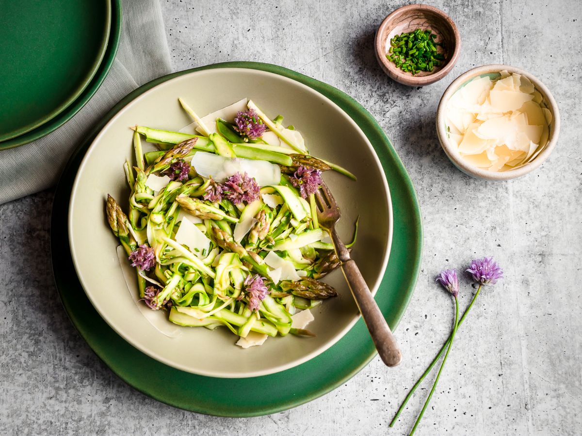 Plate of wild asparagus salad with shaved parmesan cheese and chives.